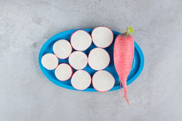 Red radish and leaves in on a gray background. High quality photo