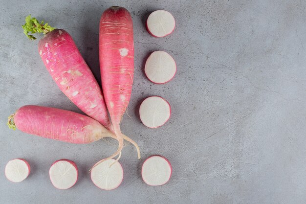 Red radish and leaves in on a gray background. High quality photo