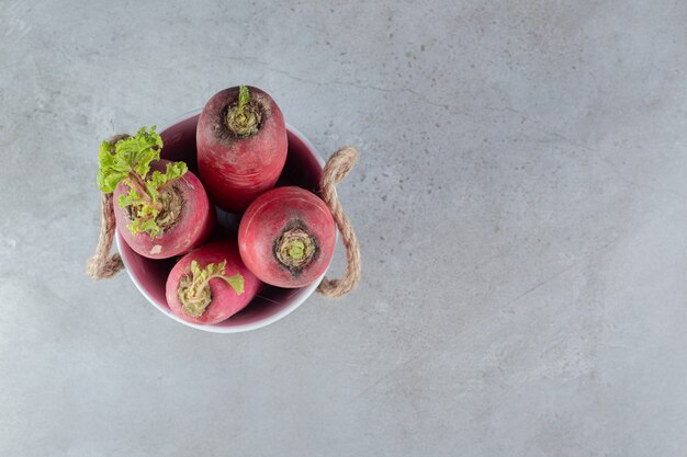 Red radish and leaves in on a gray background. High quality photo