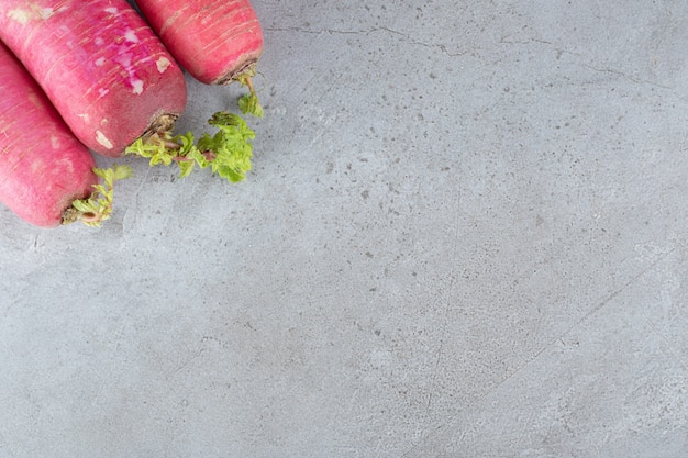 Red radish and leaves in on a gray background. High quality photo