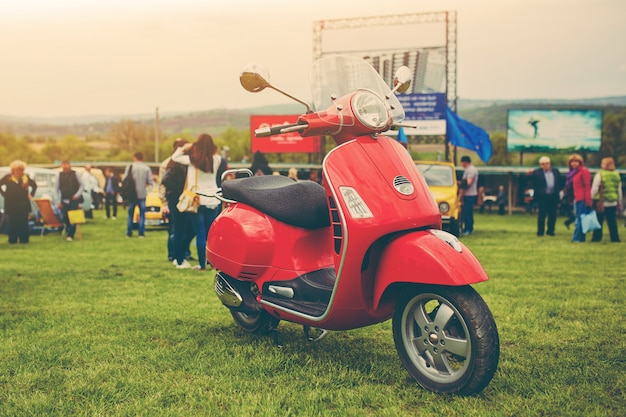 Красный ретро скутер на траве