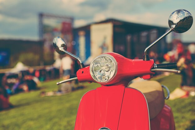 Red retro scooter on grass