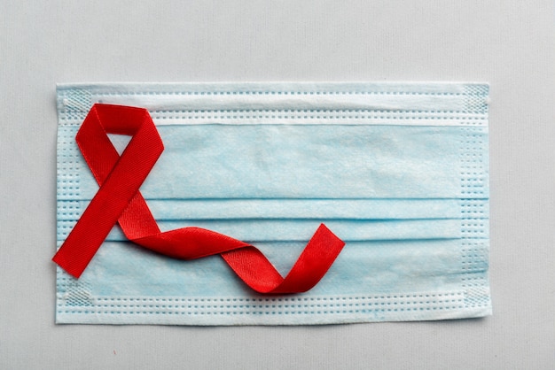 無料写真 白い背景の赤いリボンと注射器。 hivエイズリボンの認識