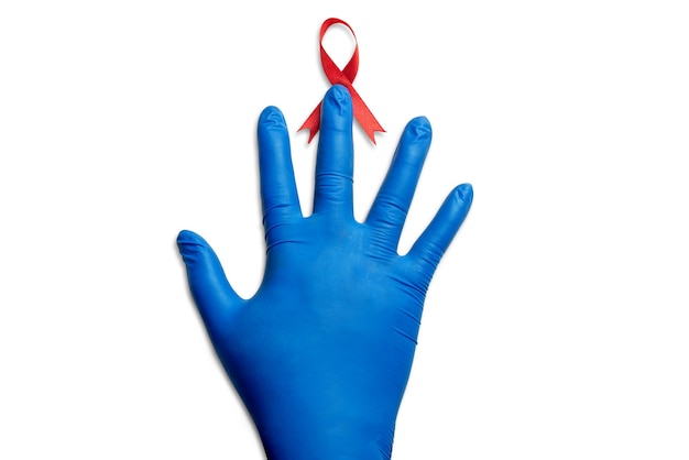 赤いリボンと白い背景の医療用手袋。 HIVエイズリボンの認識