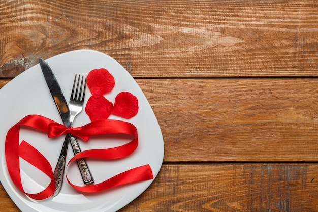 Красная лента на тарелке на деревянном фоне. Концепция Дня святого Валентина.