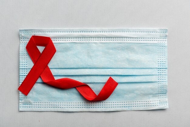 Red ribbon and syringe with white background. Hiv Aids ribbon awareness