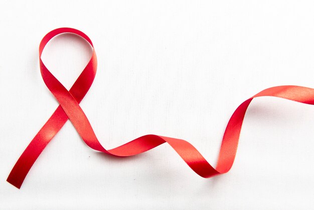 白い背景の赤いリボン。 HIVエイズリボンの認識