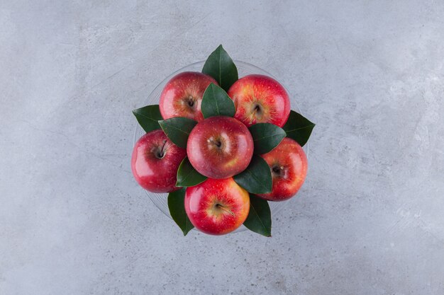 Red ripe apple fruits placed on a stone table.