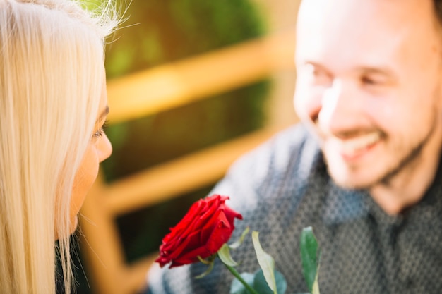 Red rose between the couple's face