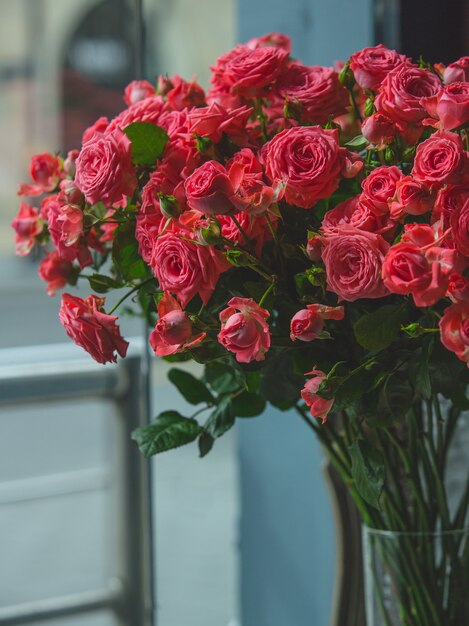 部屋の透明なガラスの花瓶の中の赤いバラ。
