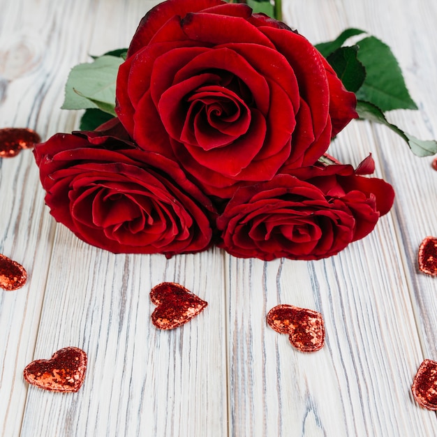 Red roses with small hearts on table