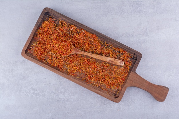 Red saffron seeds isolated on a wooden platter. High quality photo