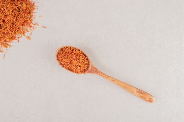Red saffron spices in a wooden spoon.