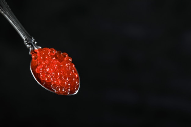 Free photo red salmon caviar in a metallic spoon