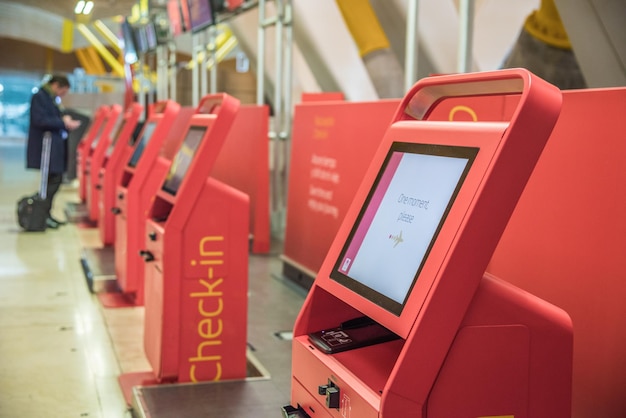 Servizio di check-in automatico delle macchine automatiche rosse presso il chiosco dell'aeroporto