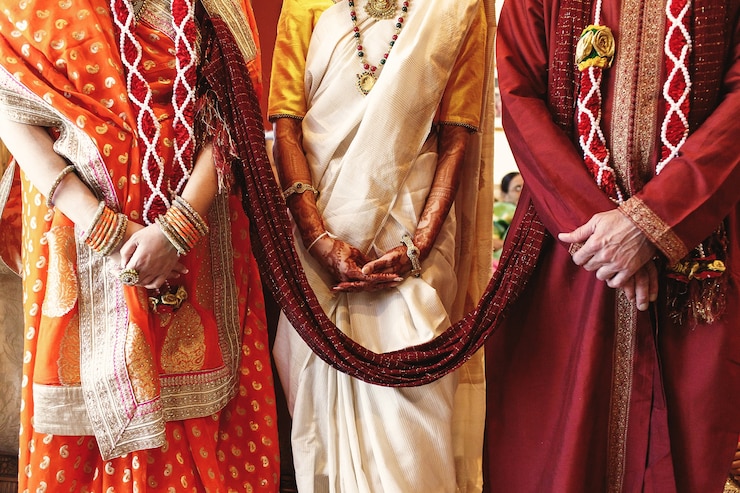 Free Photo red shawl connects bride's parents dressed for indian wedding