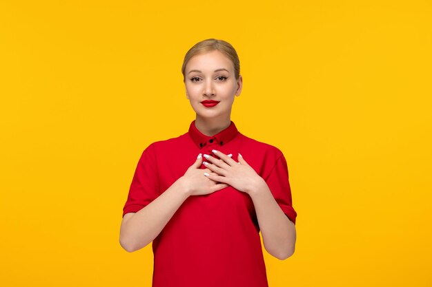 Red shirt day cute girl holding her chest in a red shirt on a yellow background