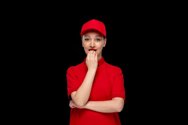 Red shirt day girl biting fingers in a red cap wearing shirt and bright lipstick