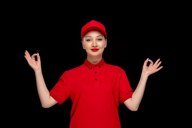 Red shirt day girl showing zen gesture in a red cap wearing shirt with lipstick