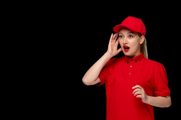 シャツと明るい口紅を身に着けている赤い帽子の開いた口を持つ赤いシャツの日ショックを受けた女の子