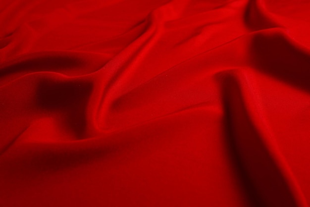 Красный шелк или атласную роскошную текстуру ткани можно использовать в качестве абстрактного фона. вид сверху.