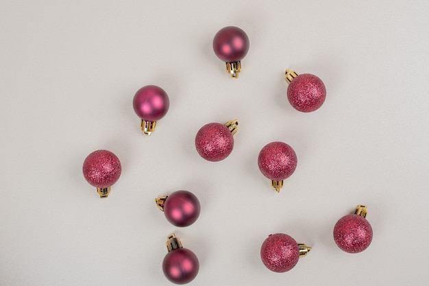 Red small Christmas balls on white surface