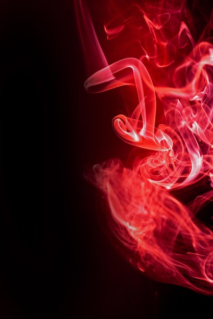 Движение красного дыма на черном фоне Premium Фотографии