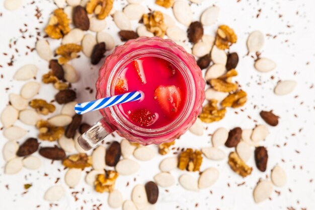 Red smoothie in jar with plastic straw