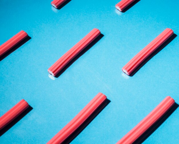 Red soft licorice candies arranged on blue background