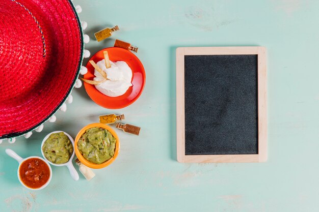 Red sombrero and sauces near blackboard