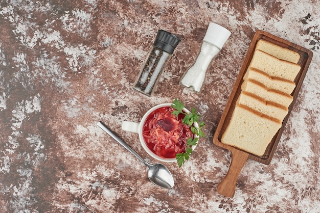 Red soup with bread slices and spices.