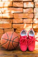 Foto gratuita pattini e pallacanestro rossi di sport contro la pila di muro di mattoni