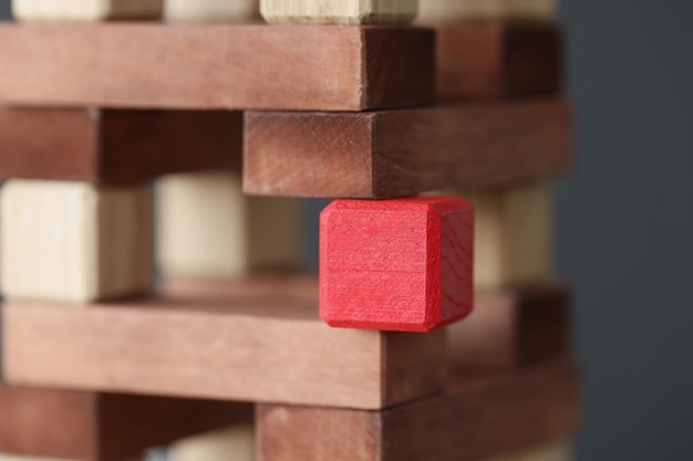 Красный квадрат деревянный куб, стоящий среди крупного плана деревянных блоков. концепция уникальных способностей