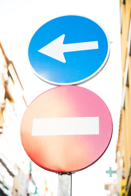 Red stop street sign and directional sign on road