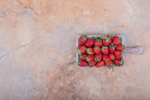 Red strawberries in a blue rustic platter