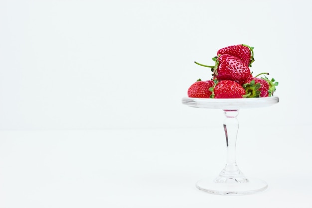 Red strawberries on a glass stand.