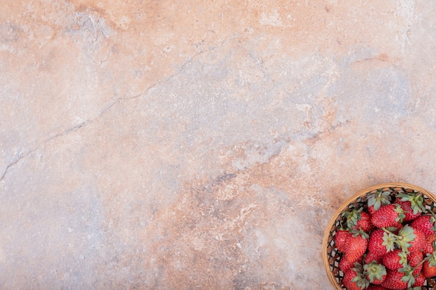 Red strawberries in a pottery bowl on the marble