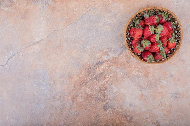 Fragole rosse in una tazza di ceramica su marmo.