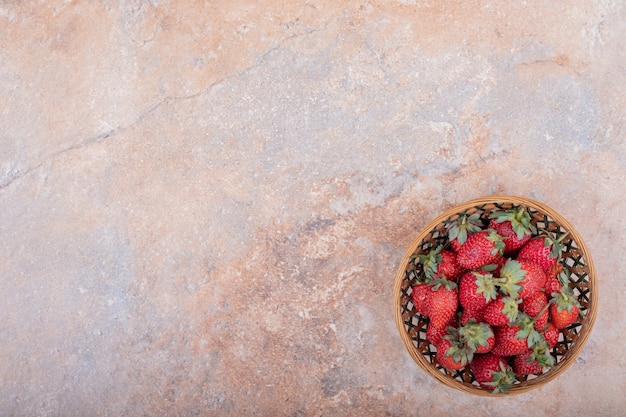 Foto gratuita fragole rosse in una ciotola di legno rustica