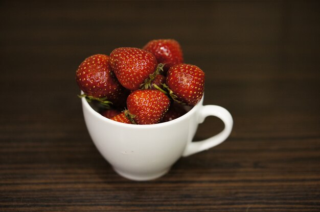 Red strawberries in a white cup