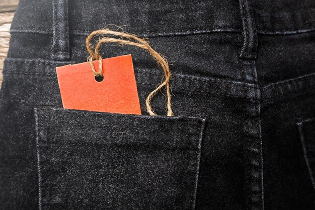 Red tag in the back pocket of black jeans. black friday sales