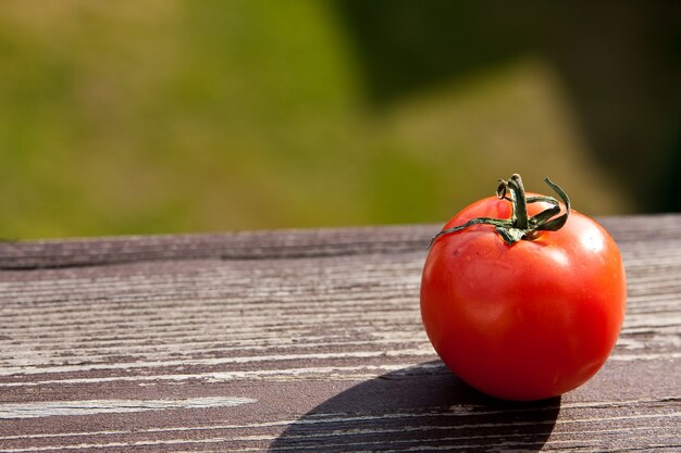 Red tomato put on a wooden surface