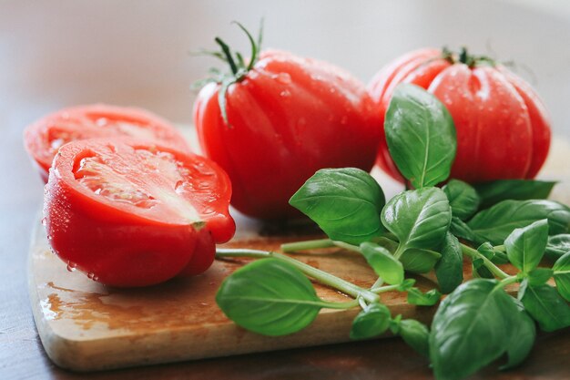 Red tomatoes and mint leaves on a wooden board