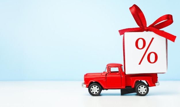 Red toy car and gift with percent sign