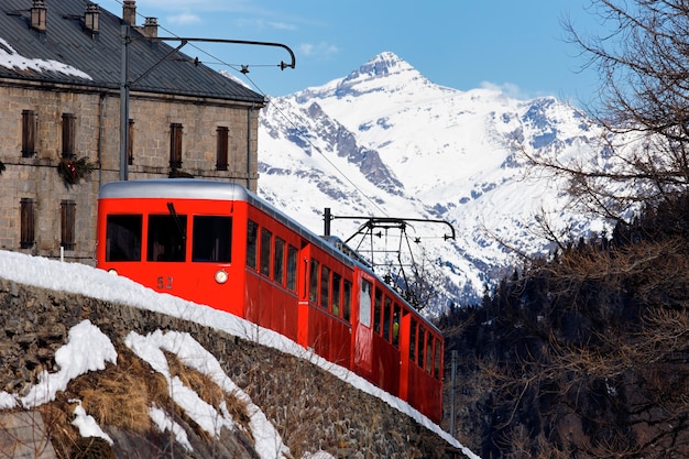 Красный поезд во французских альпийских горах зимой