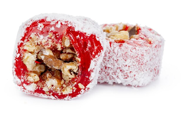白で分離された粉砂糖のナッツと赤いトルコ菓子