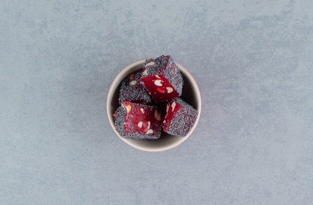 Red Turkish delights in the bowl, on the marble background. High quality photo