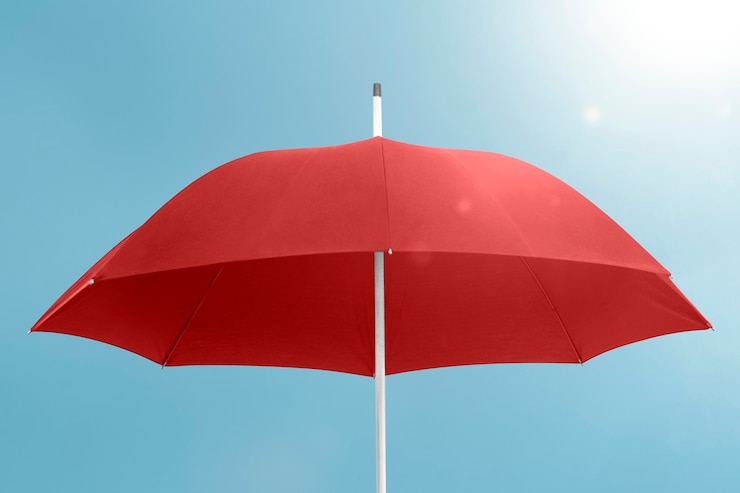 Free Photo red umbrella with copy space on blue sky