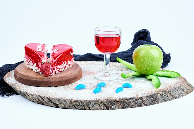 A red valentine cake with a glass of drink.