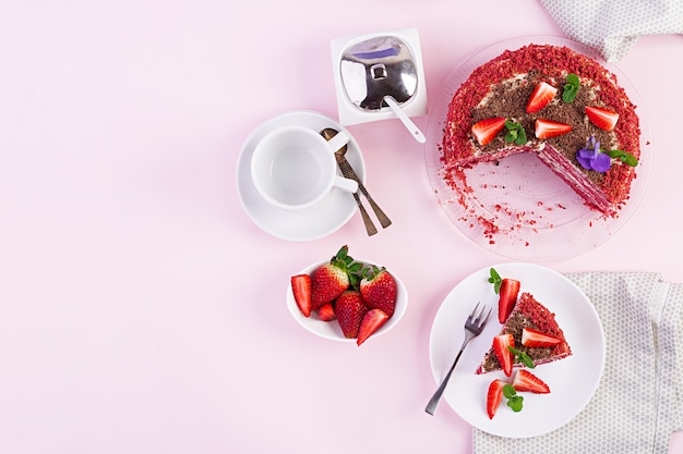 Red velvet cake on a pink table. Tea drinking. Table setting. Top view